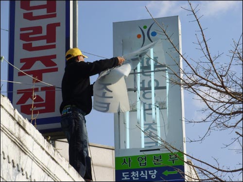 함양리조트 현장 사무실 간판을 철거하는 주민들. 